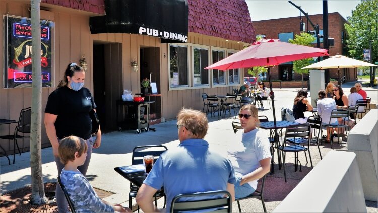 Customers at JW's Food and Spirits in Grand Haven take advantage of expanded outdoor seating into former parking spaces.