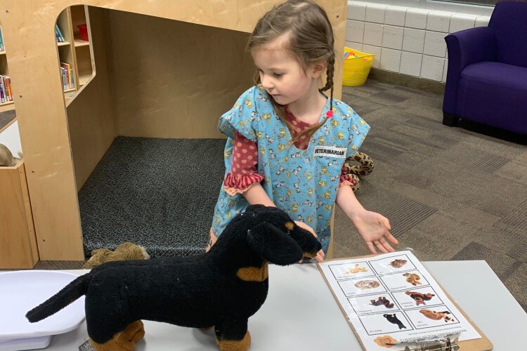 Willow Davis, 6, plays veterinarian at the Kent District Library's Walker branch.