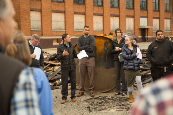 Justin Beene, second from the left, speaks at the the site of Rising Grinds. 