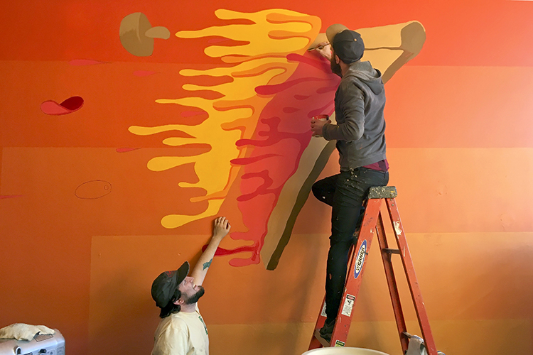 Derek Copp & Nick Nortier paint an interior wall of Good Pizza Co.