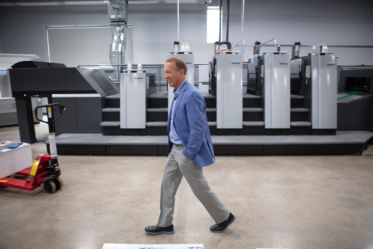 Walt Gutowski Jr. walks past the new presses at Swift Printing. 