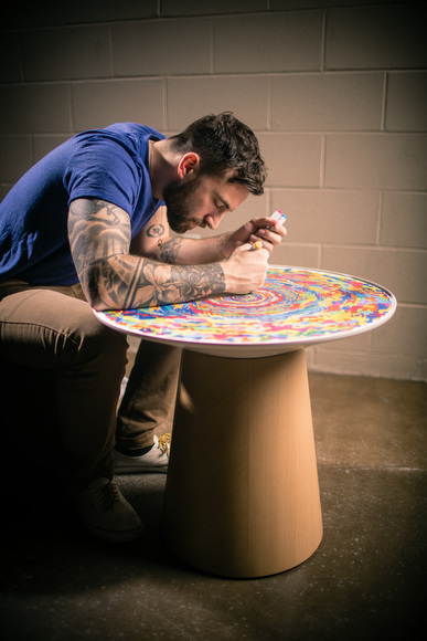 Chuck Anderson writes on the table he designed for Turnstone.