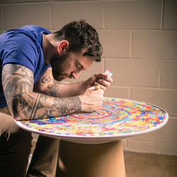 Chuck Anderson writes on the table he designed for Turnstone.