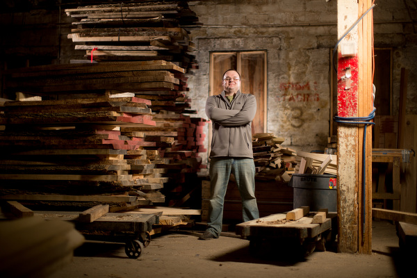 KC Weaver stands in front of stacks of curing elm wood.