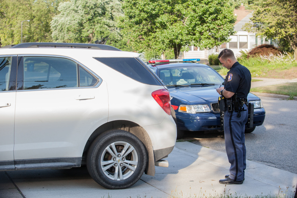 Officer Ryan Manser checks ownership history of a car while on a call.