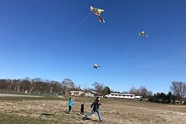 Kids fly kites at a sports gear giveaway at the Kinross Recreation Center.