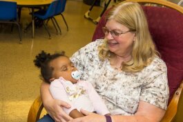 Kathy McNinch with a child at the Kalamazoo Drop-In Child Care Center.