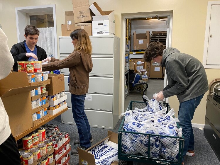Volunteers at Love In Action of the Tri-Cities sort food donations. 