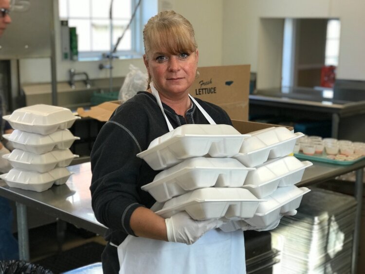 Community Kitchen Assistant Rachel Nolan holds hot meals boxed and ready to go home with those who come daily to the soup kitchen.