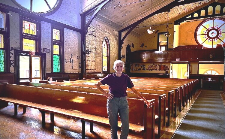 Carol Moore, local preservationist and founder of Hermitage at Diamond, stands in the sanctuary of the 150-year-old former East Hills church she is restoring.