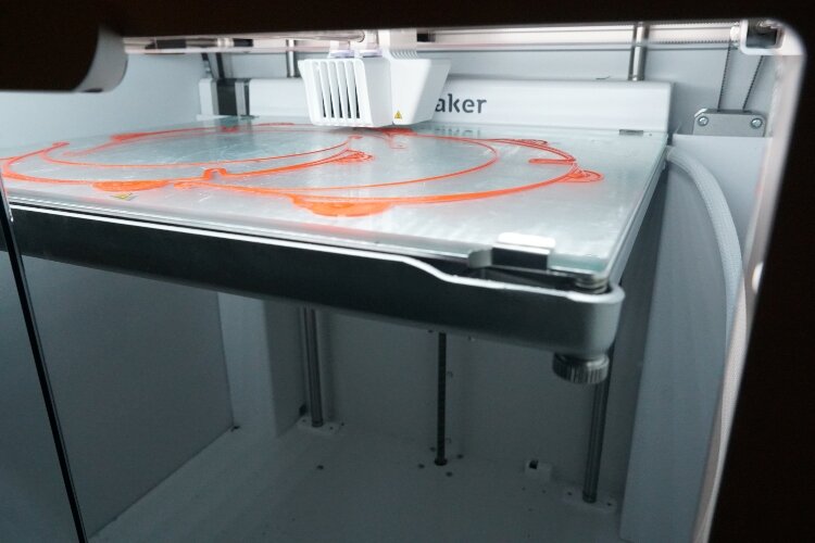 A Herman Miller 3D printer produces a face shield. 