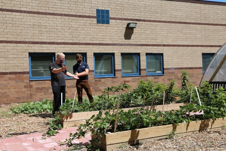 Bill Boerman, Holland Middle School teacher and founder of the greenhouse, speaks with Gentex engineer Elliot Busta