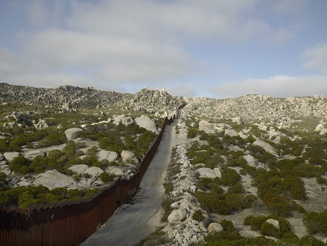 A photo in the “Border Cantos | Sonic Border" exhibit shows a fence erected on the Mexican border. 