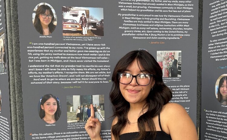 Jennifer Pham stands in front of the GR Stories display, showcasing her contribution.