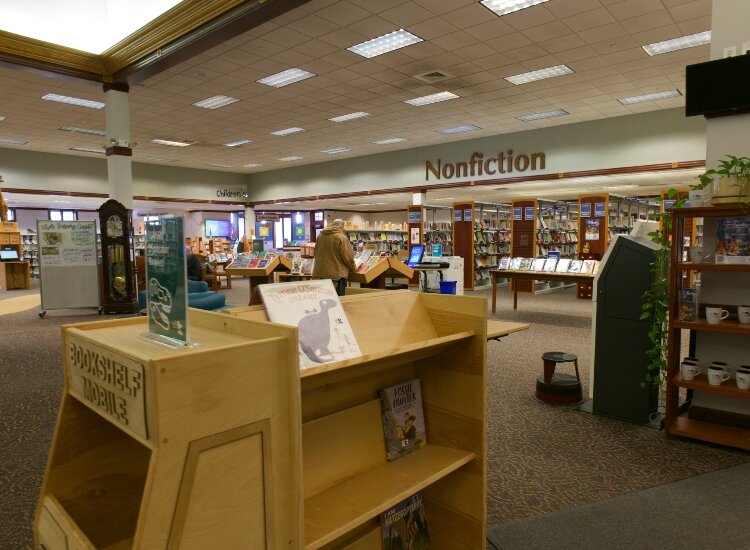 A patron looks for a book at the Kent District Library Cascade Township branch is a resource for many older patrons.