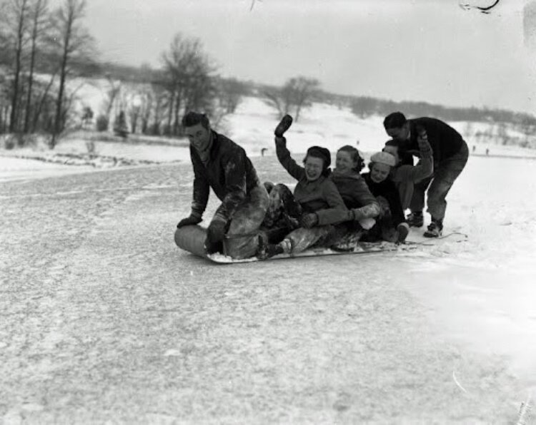 Young men and women are shown sledding on a toboggan at Kent Country Club in this Grand Rapids History Center archive photo.