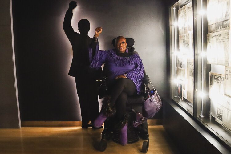 Kimberly Kennedy-Barrington raises her fist to join Mandela at the exhibit.