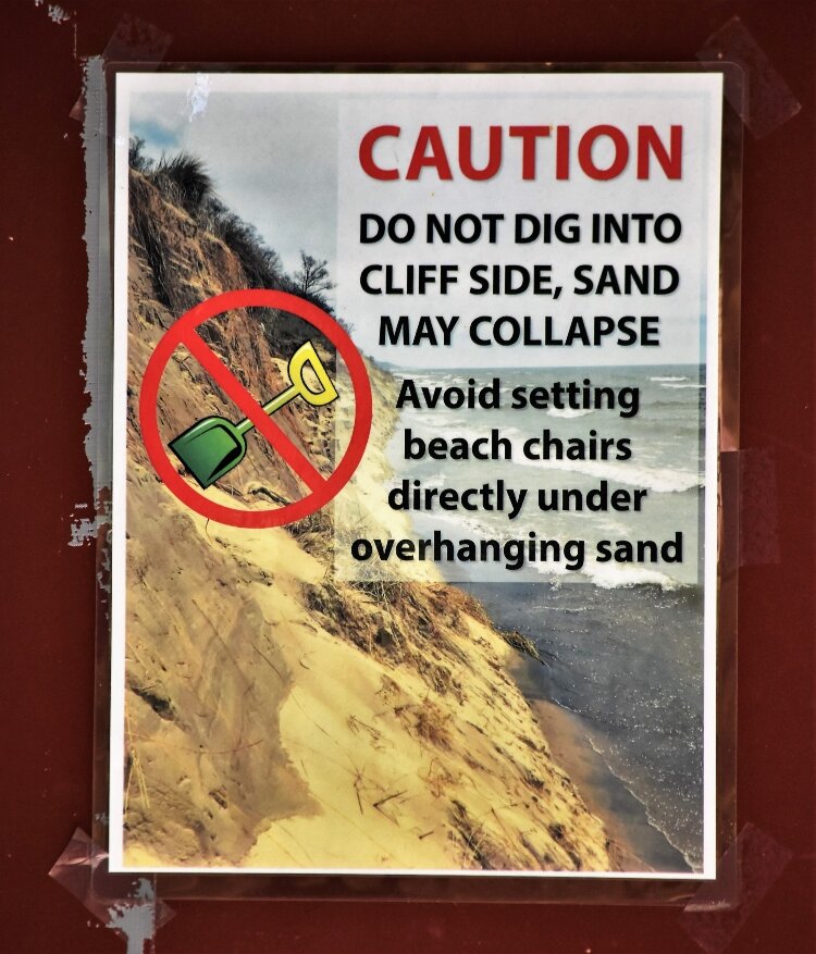 Warning signs alert visitors to dangers of beach erosion at Ottawa County lakeshore parks.