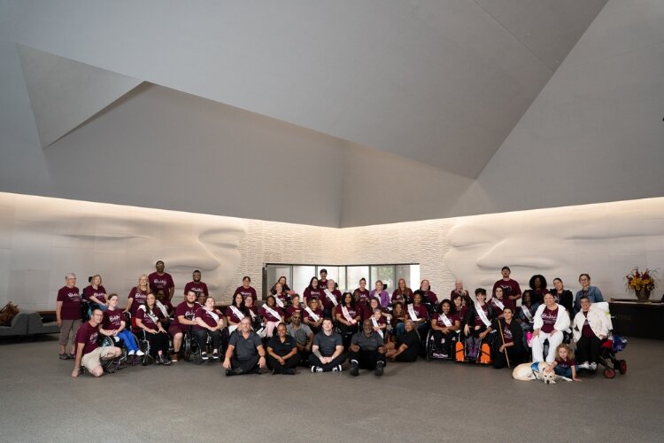 Contestants and staff of Ms. Wheelchair America 2025 gather for a group photo at Meijer Gardens.