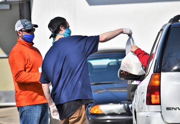 Employees at deBoer Bakkerij and Dutch Brothers Restaurant in Holland safely serve drive-thru customers.