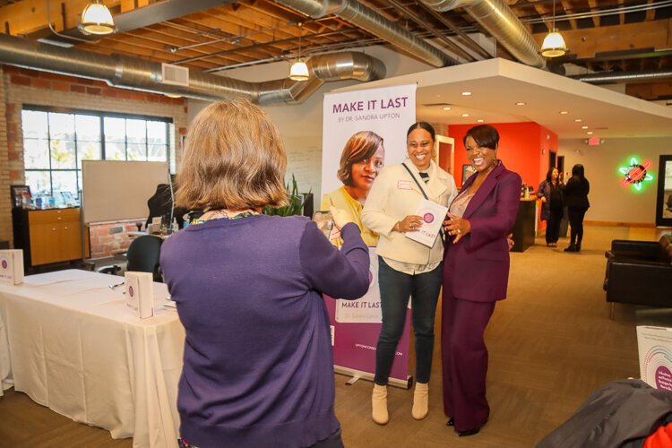 Sandra Upton takes a photo with an attendee at her book launch. 