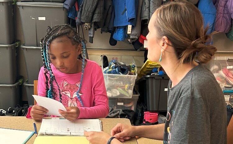 A SLD Read volunteer works with a student. 