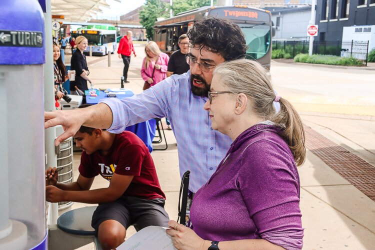 A Rapid team member assists Gail Mancewicz, who has limited vision.