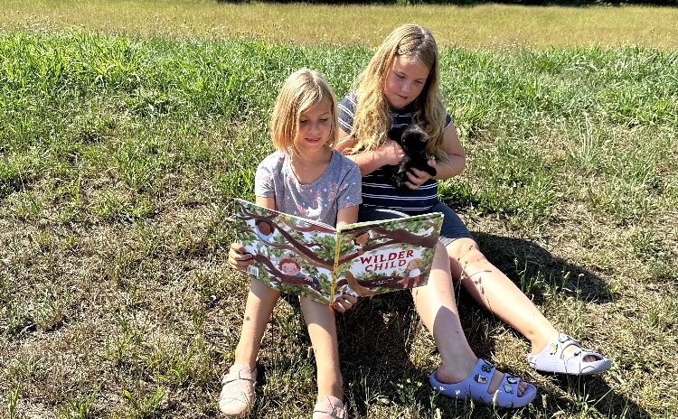 Vivienne Blanco Bond, 9, and her sister, Serafina, 7, take part in KDL’s Summer Wonder program by reading "The Wilder Child," written by their aunt, Nicolette Sowder.
