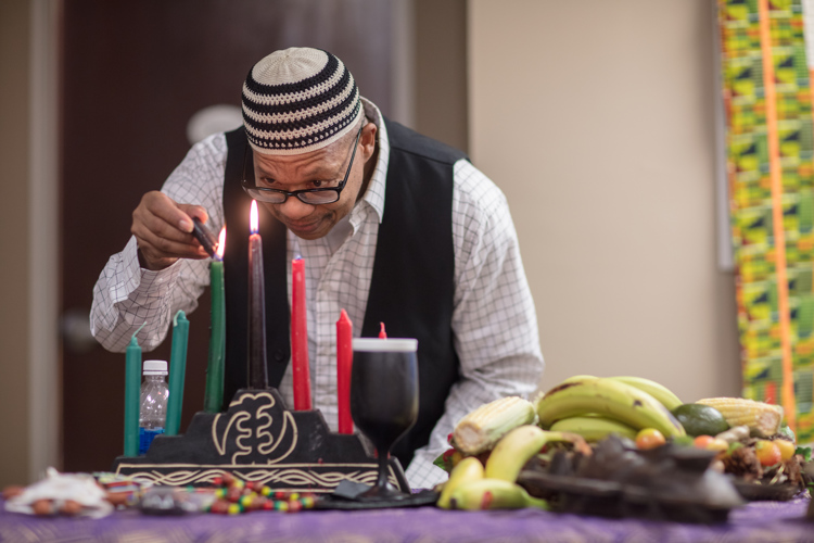 George Bayard lights Kwanzaa candles at the museum to celebrate the holiday.