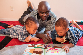 Tetusa Ndalamba works on reading with his daycare kids.