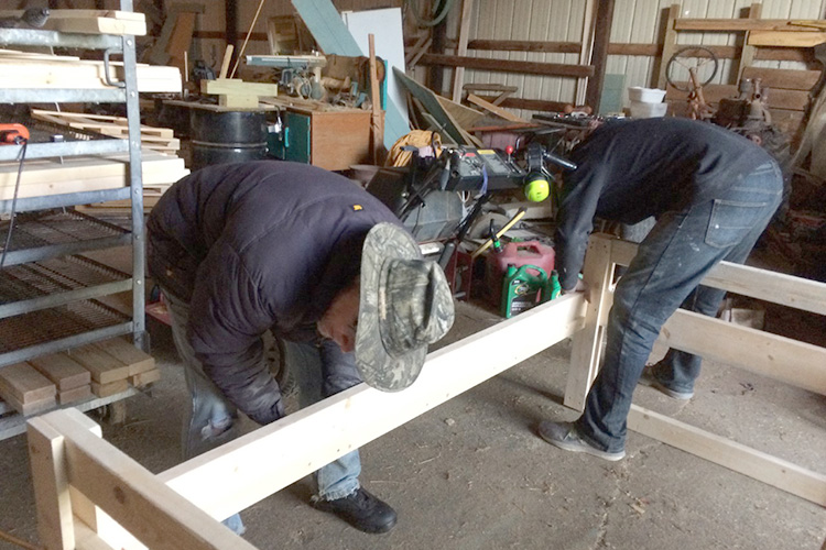 Jim Thompson teaches Jason Lee how to construct a bunk bed in Thompson’s barn.