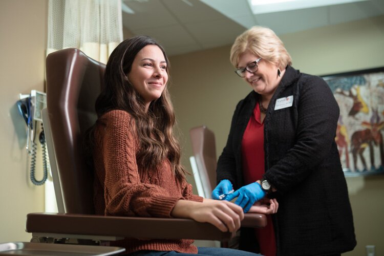 Tori Champion gets a shot from Barbra Mustert at Calvin Health Services.