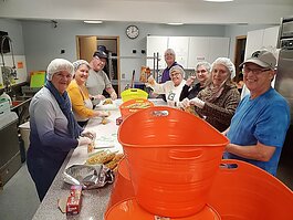 Kids Food Basket volunteers pack meals at Peace Lutheran Church in Holland. 