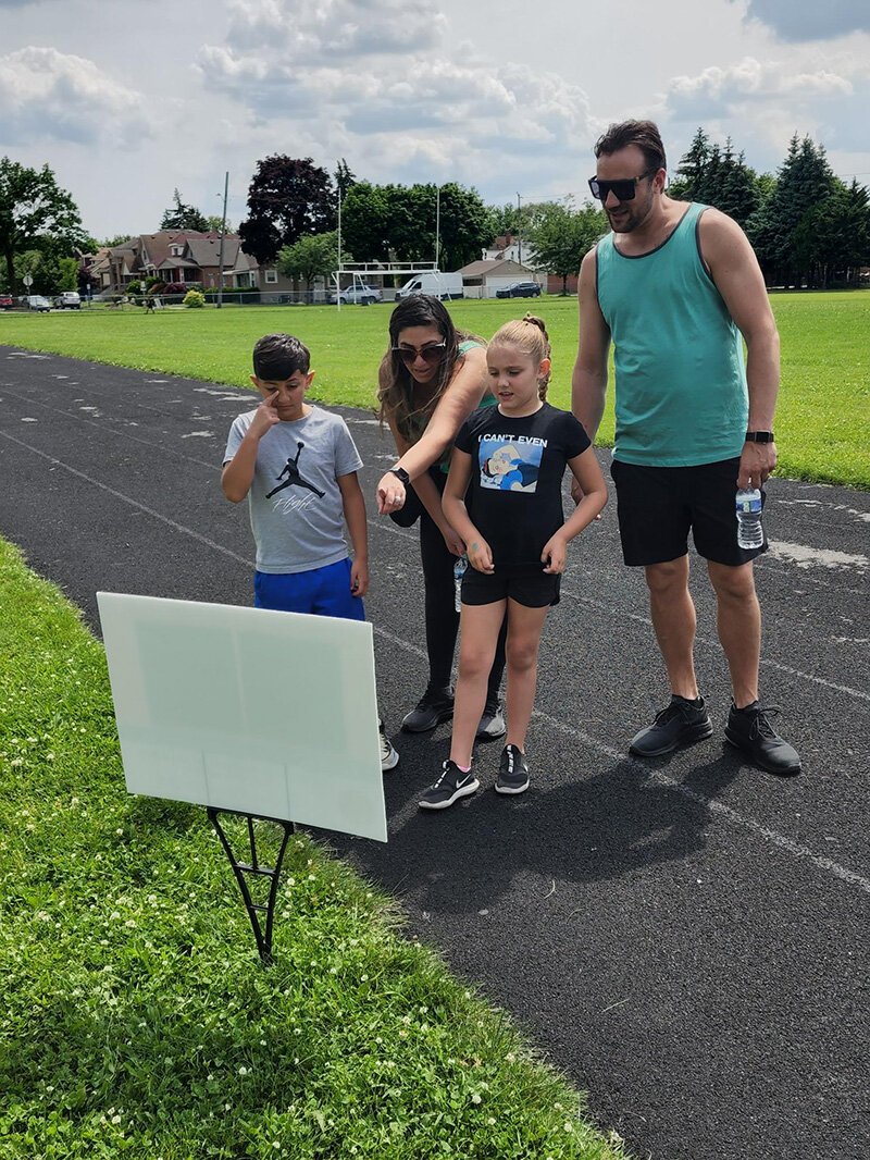 A family enjoys a StoryWalk®.