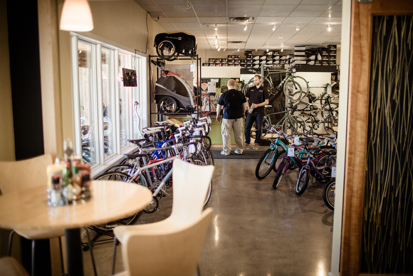 The cafe is next door to the bicycle shop.