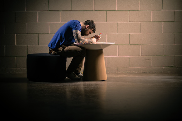 Chuck Anderson writes on the table he designed for Turnstone.