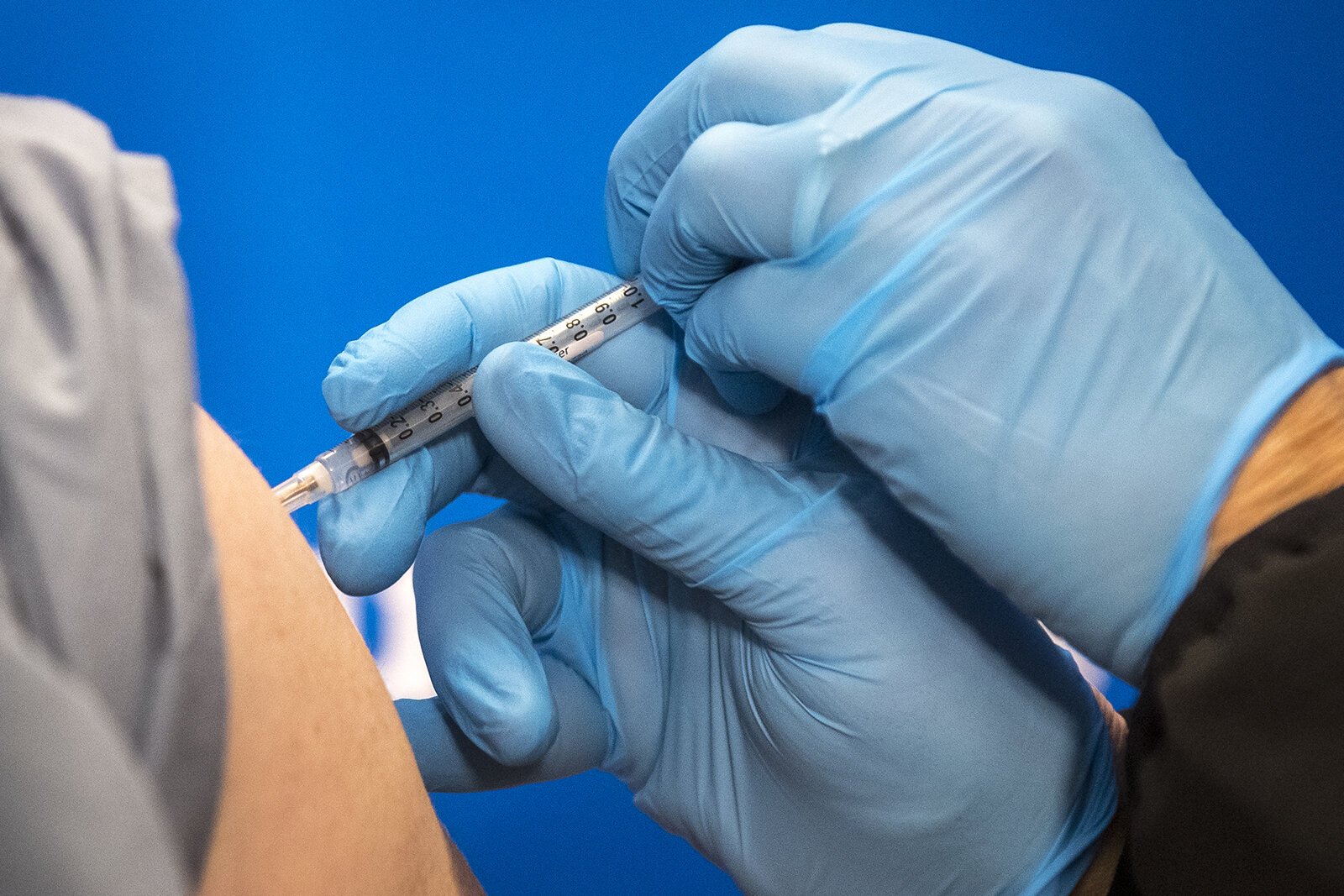 Carolyn Wilson administers the first dose of the COVID-19 vaccine to Dr. Eric Kane at Beaumont Service Center in Southfield on Dec. 15, 2020.