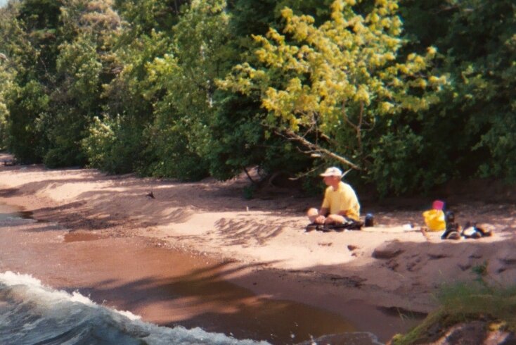 Paul Ecklund is shown sitting on beach during a camping trip to Wisconsin's Apostle Islands in 1995. (Paul Ecklund)
