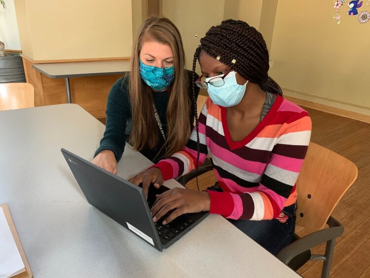 Boys & Girls Club of Greater Holland Teen Center Director, Sara Delbene, helps a teen with her homework on a Wi-Fi enabled device.