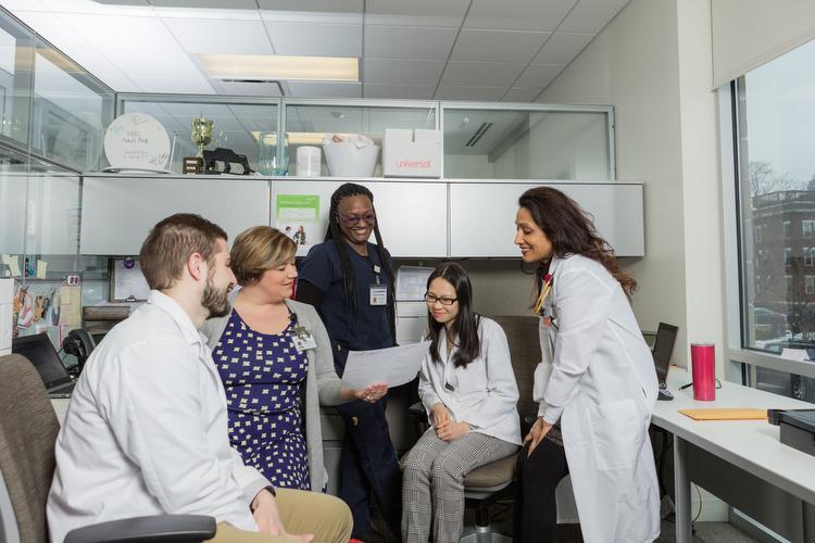 Members of Cherry Health's integrated care team confer. The team includes nurses, medical assistants, pharmacists, and physicians.