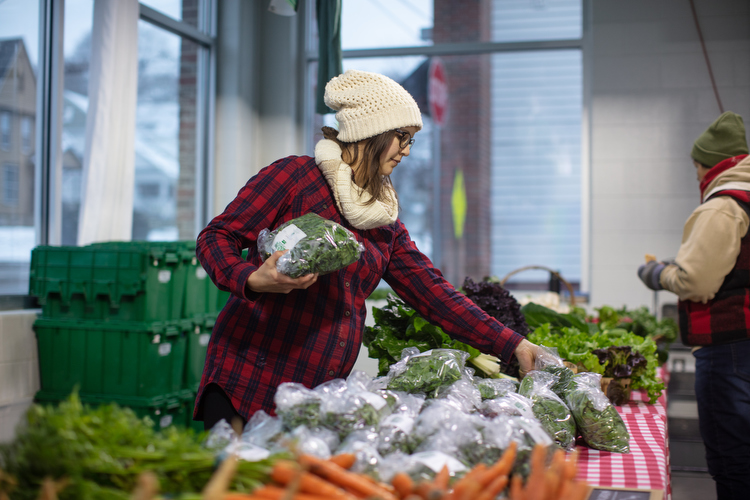 Heather Anderson from Green Wagon Farm helps a customer find nutrient-dense greens.