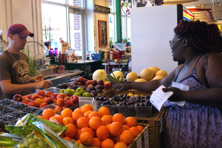 Geamill Gibson buys produce using a doctor's prescription at the Flint Farmers Market.   