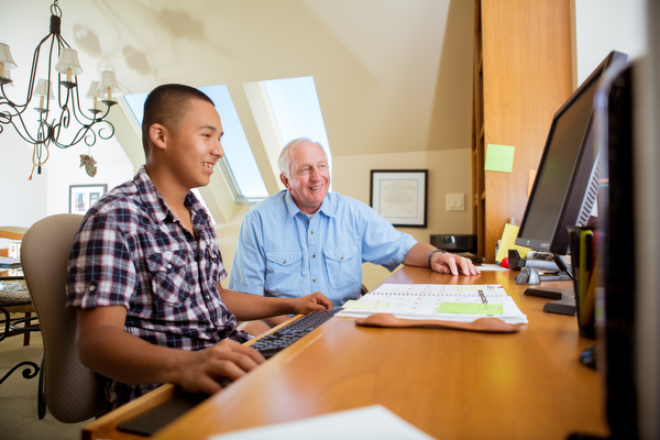 Gary Zell works with Javier on school work at the family computer.