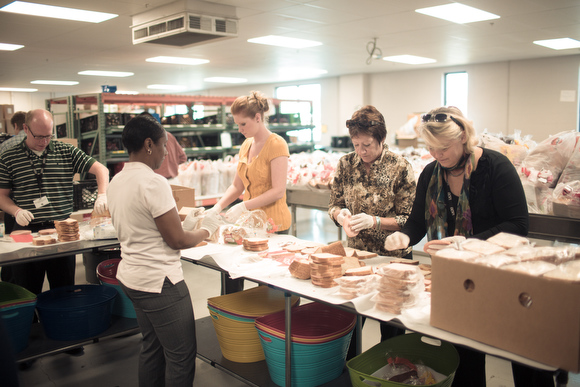 Kids food basket volunteers make bag dinners.