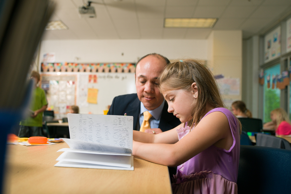 Jesus Santillán, principal at Ada Vista Elementary helps a student with reading.