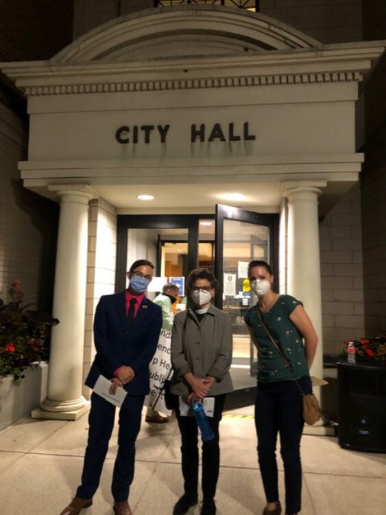 Jeffrey Sorensen, the Rev. Jennifer Adams, and Sara Van Tongeren stand outside Holland City Hall after a civil rights ordinance passed Aug. 19.