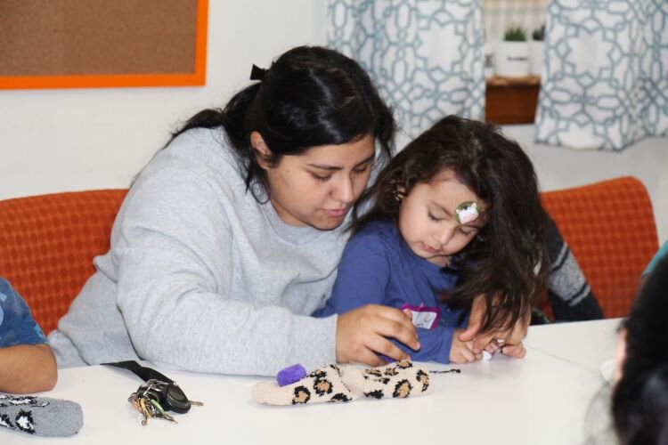 Parent works with child on SEL craft.