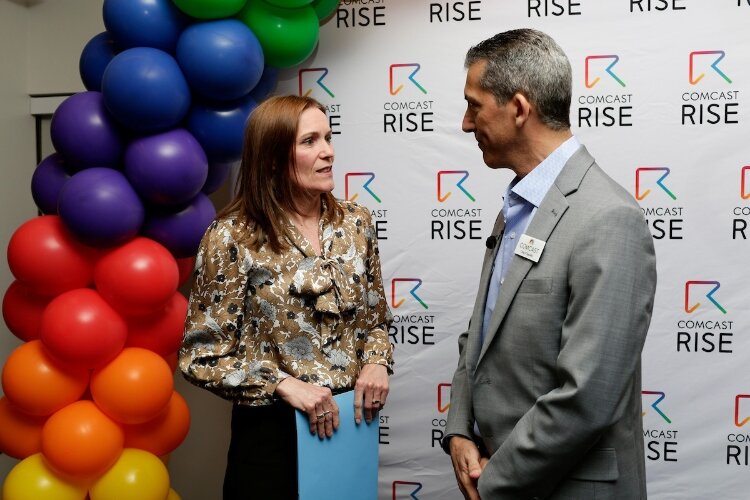 Michigan Senate Majority Leader, Winnie Brinks, left, and Craig D’Agostini, Vice President of External Affairs at Comcast, are seen talking during the Comcast RISE kickoff event at the Grand Rapids Chamber on April 22 in Grand Rapids. 