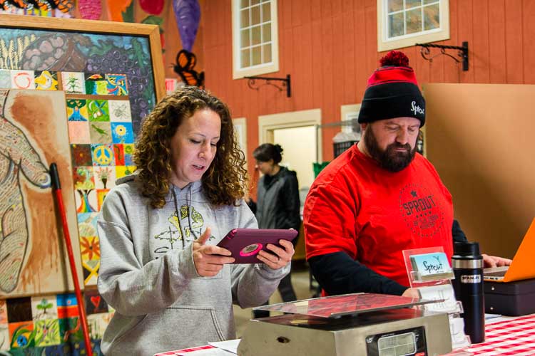 Lydia Marucco and Jeremy Andrews serve customers at Sprout's retail food store.