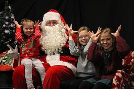 Children share a holiday greeting in Sign Language during their photo with Signing Santa. (DHHS)